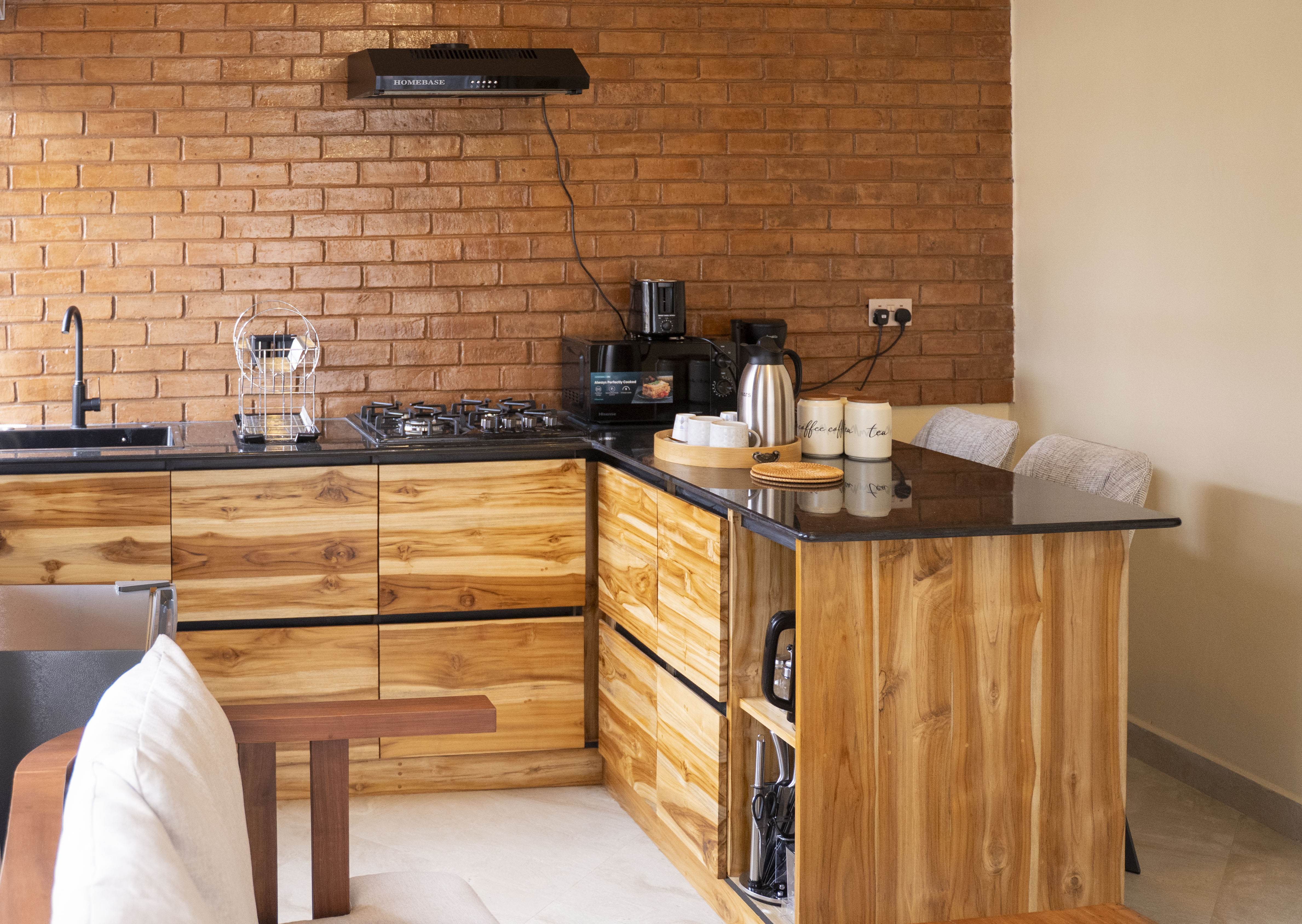 The fully-equipped kitchen — black granite countertops, gas hob and handcrafted mninga cabinetry